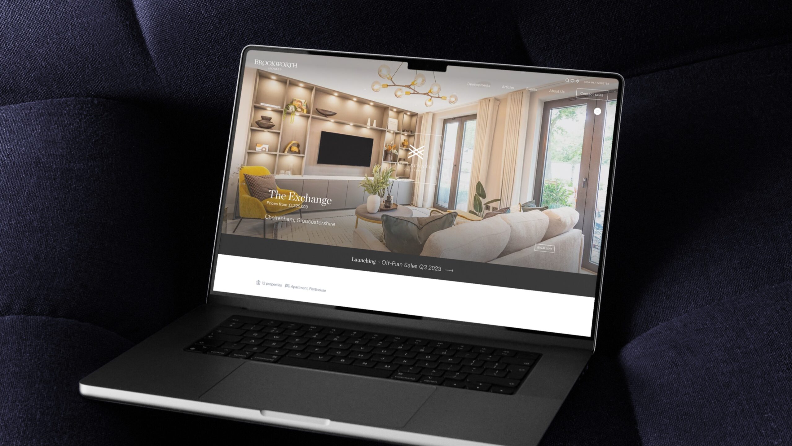 A macbook with a modern, contemporary property website displayed on the screen