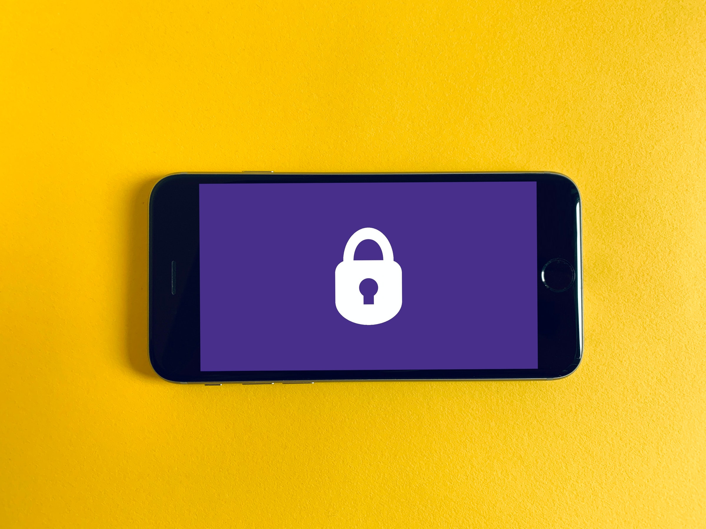 An iPhone with a purple security image on a yellow background